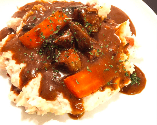 Beef and Guinness stew, plated with mashed potatoes