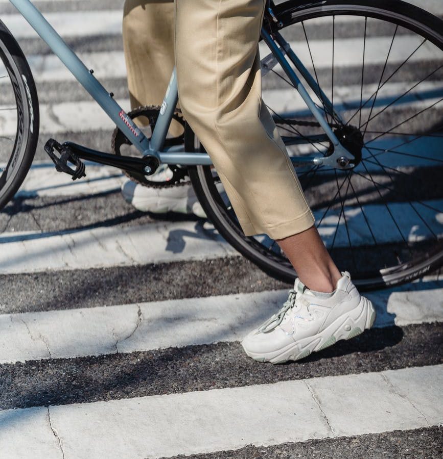 unrecognizable woman riding bicycle on crosswalk